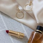 gold hoop earrings with perfume and lipstick…